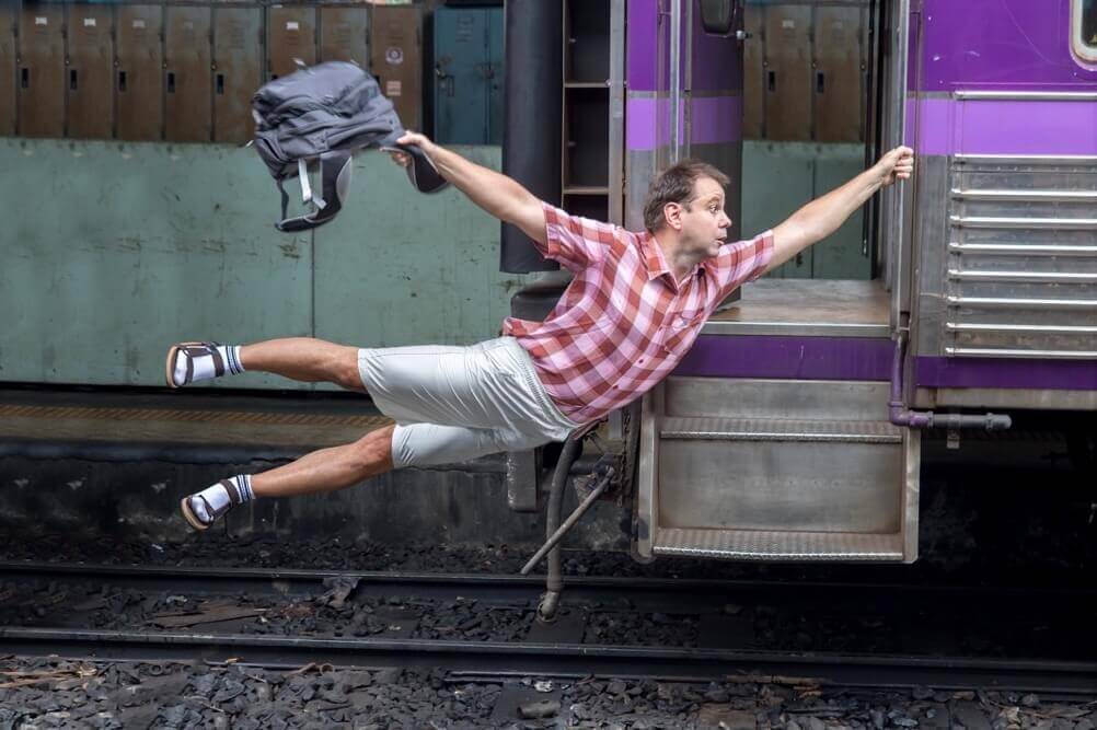 Man holds onto a moving train